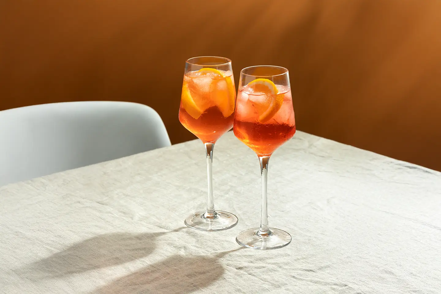 hi-Dry_alkoholfreier-aperol Alkoholfreier Aperol steht im Glas auf einem Tisch