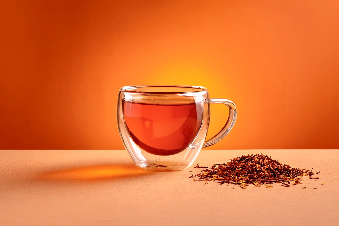 Roiboos-Tee in einer schönen Tasse vor orangenem Hintergrund